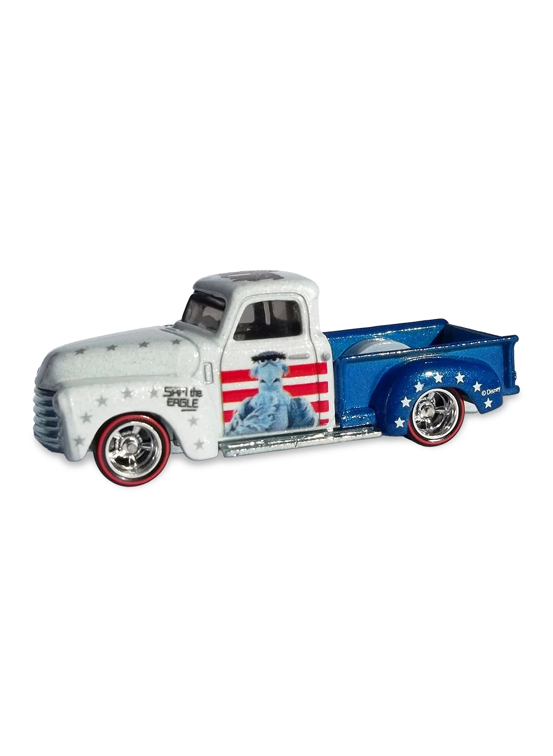 Close-up view of the patriotic white and blue Hot Wheels Sam Eagle '52 Chevy Truck showing side flag graphics and redline Real Riders wheels.