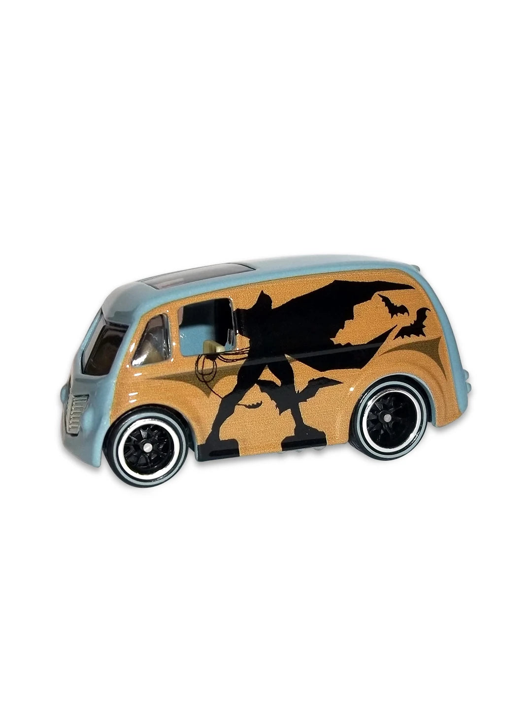 Close-up view of the two-tone tan and blue Hot Wheels Batman Quick D-Livery van showing side comic panel art and black Real Riders wheels.