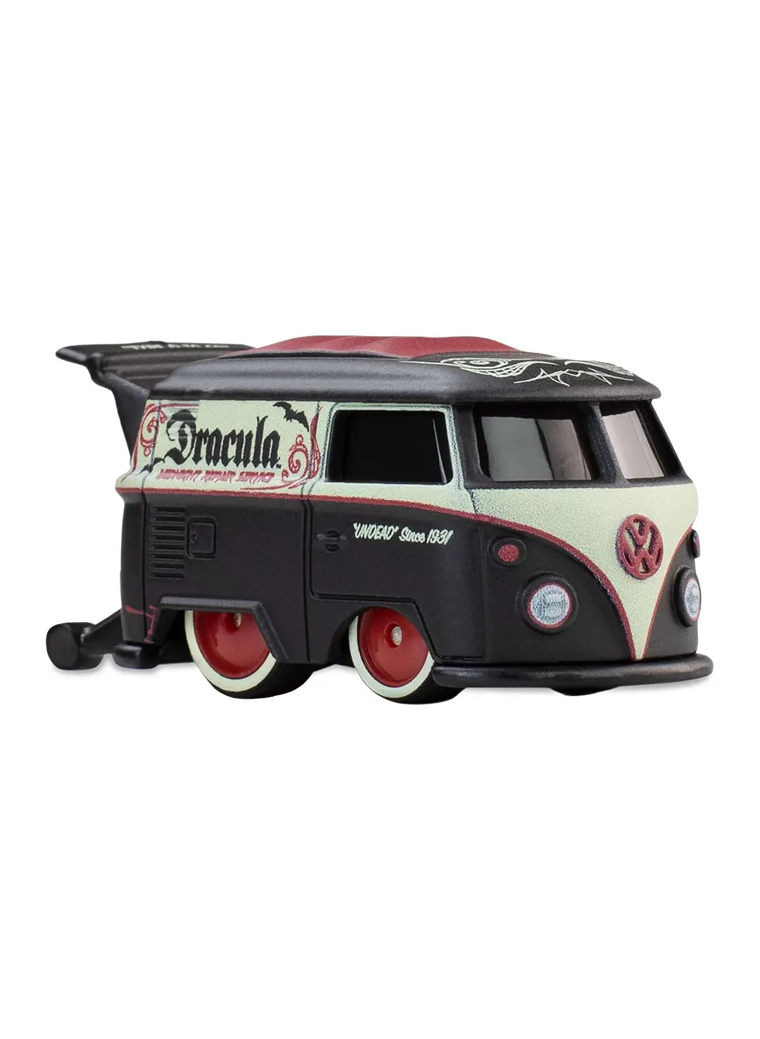 Close-up view of the matte black Hot Wheels Dracula Kool Kombi showing side "Midnight Repair Service" text graphics, custom surfboards out the back, and dark red chrome Real Riders wheels.