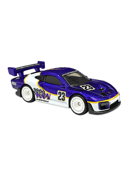 Close-up side view of the premium white Hot Wheels Porsche 935 showing detailed racing decals, crisp sponsor graphics, aerodynamic racing body kit profiles, and matching black Real Riders wheels with deep dish hubs.