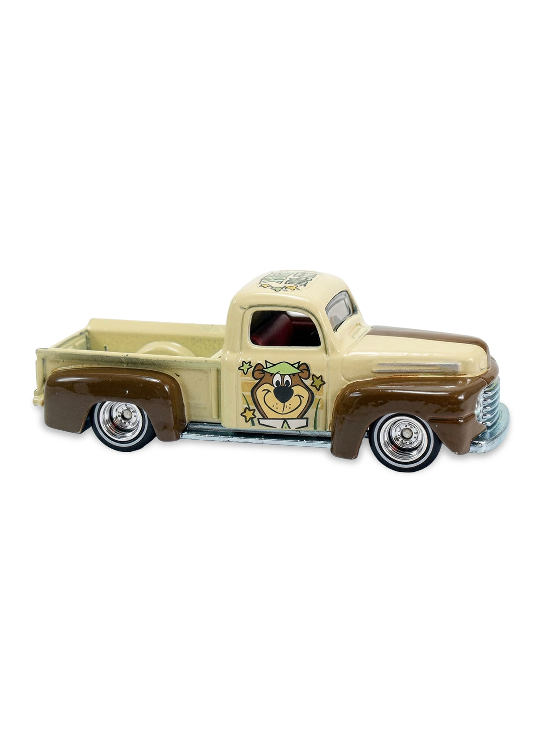 Close-up view of the beige and brown Hot Wheels Yogi Bear '49 Ford F1 truck showing side door graphics and chrome Real Riders wheels.