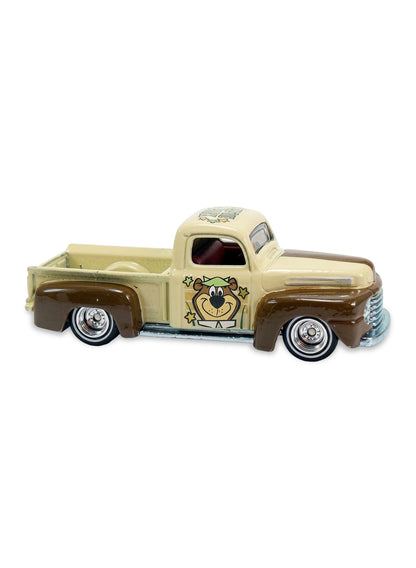 Close-up view of the beige and brown Hot Wheels Yogi Bear '49 Ford F1 truck showing side door graphics and chrome Real Riders wheels.