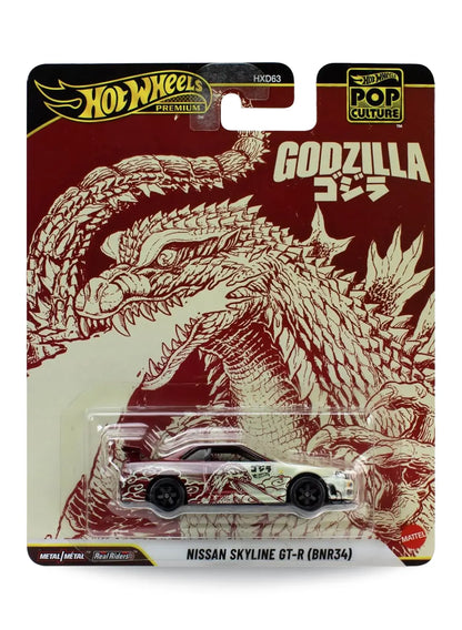 Hot Wheels Premium Pop Culture Godzilla Nissan Skyline GT-R (BNR34) 1:64 scale premium diecast car mint on its original Japanese kaiju themed blister card with dark red textured Godzilla comic line-art.
