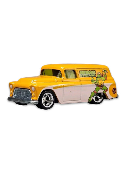 Close-up view of the white and orange Hot Wheels Michelangelo '55 Chevy Panel truck showing side graphics and chrome wheels.