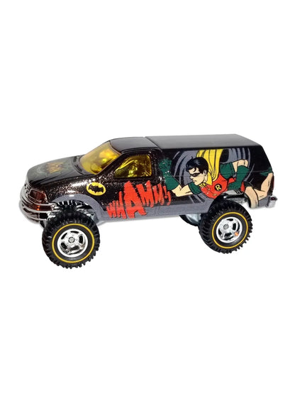 Close-up view of the metallic dark grey Hot Wheels Robin Ford F-150 truck showing side comic action graphics and chrome Real Riders wheels.
