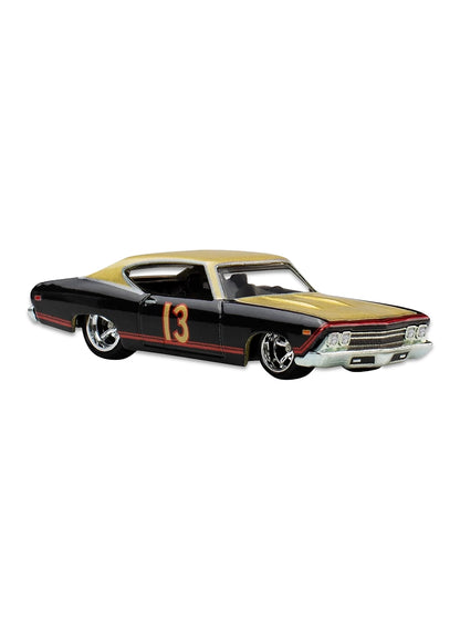 Close-up view of the gloss black Hot Wheels Ricky Bobby '69 Chevelle SS 396 stock car showing a gold roof split, gold side racing stripes with number 13 decals, and chrome deep-dish Real Riders wheels.