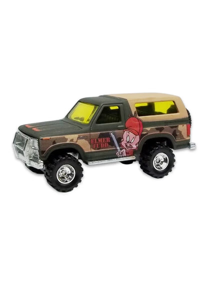 Close-up view of the matte green Hot Wheels 2013 Elmer Fudd '85 Ford Bronco showing side camouflage graphics and deep-dish chrome Real Riders wheels.