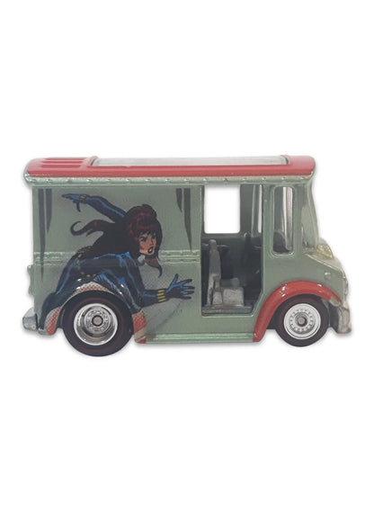 Close-up view of the grey Hot Wheels Black Widow Bread Box truck showing its red roof, side comic panels, and chrome Real Riders wheels.