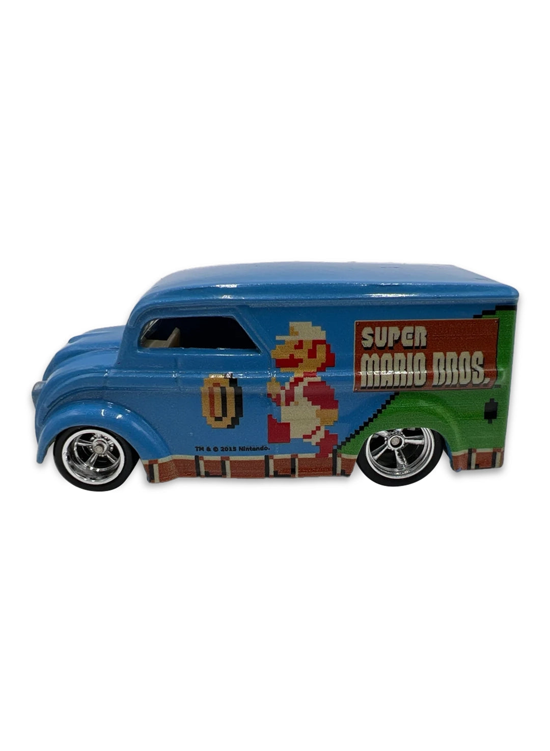 Close-up view of the metallic blue Hot Wheels Super Mario Bros. Dairy Delivery truck showing side 8-bit pixel graphics and chrome Real Riders wheels.