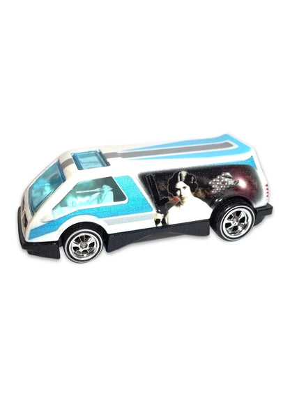 Close-up view of the white Hot Wheels Princess Leia Dream Van XGW Panel showing blue stripes, side movie graphics, and chrome Real Riders wheels.