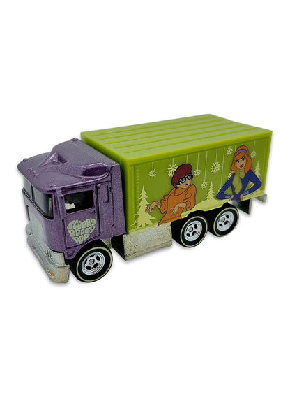 Close-up view of the dark purple Hot Wheels Daphne and Velma Hiway Hauler truck showing a green cargo box and chrome Real Riders wheels.