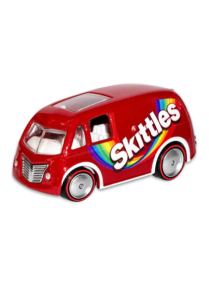 Close-up view of the glossy red Hot Wheels Skittles Quick D-Livery van showing side rainbow graphics and red-rimmed Real Riders wheels.